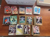 Overview photo showing unopened Topps NBA basketball cards, unopened Upper Deck packs, and multiple stacks of loose basketball and baseball cards.