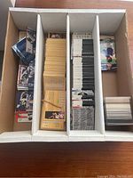 Top view of divided box with bulk cards in several categories separated into sections, some cards rubber-banded or stacked