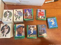 Photo showing several stacks of baseball sports cards featuring players in pitching and batting poses.