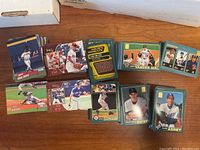 Multiple stacks of late 90s/2000s baseball cards, showcasing individual player cards from brands like Topps and Upper Deck including Carlton Fox, Jim Abbott, and Ricky Henderson among others.
