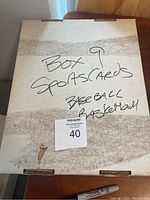 Photo of a closed cardboard box labeled 'Box 9 Sportscards Baseball Basketball'