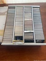 Full view of large box with four dividers, each containing hundreds of baseball cards in sleeves or loose.