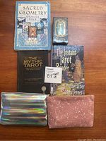 Overview of all tarot and oracle decks and related books, plus cloth bags on wooden surface.
