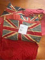 Photo showing three vintage flags including Union Jack and Ontario shield flags with aged, faded fabric.