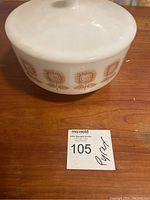 Side view of the white glass covered serving dish showing the brown floral pattern.