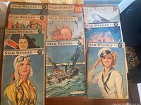 Collection of 11 Star Weekly magazines arranged showing colorful wartime and naval themed illustrated covers from the 1940s.