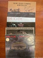 Six vinyl record covers arranged upright showing front artwork with varied artist images and text.