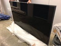 Full front view of 75-inch TV lying on bubble wrap