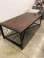 Full view of the coffee table showing wooden top with metal frame and cross pattern sides.