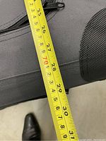 Photo showing measuring tape indicating length of approximately 28 inches on the fabric dog crate.