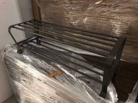 Full view of black metal two-tier shoe rack showing the structure and design.