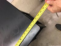 Top view of the black table showing length measurement approximately 42 inches using a yellow measuring tape.