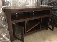 Side angle showing dark stained wood finish, open shelves at top, glass doors open revealing diagonal shelf.