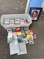 Overview of the bin with audiobook CDs and the framed Johnny Depp print beside it on the ground.