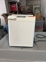 Side view of white Panasonic bread maker showing overall condition and shape.