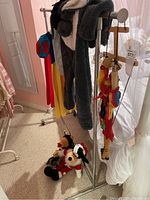 Metal portable coat rack loaded with some clothes and toys for context, but items not included.