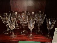 Front view of all 11 Lismore stemware glasses on a shelf.