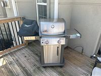 Front and side view of grill showing overall condition, fold-down shelves extended and natural gas hose connection