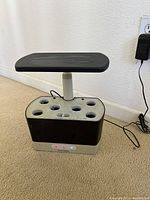 Full view of Aerogarden 6 pod with pump and adjustable light panel above and power cord attached.