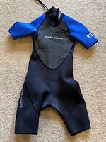 Front view of the Body Glove juniors wetsuit in size 10 with short sleeves and short legs, showing the blue and black color scheme and logo on chest.