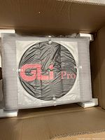 DAK Industries GLi Pro turntable inside original protective foam packaging with black cover and red logo visible.