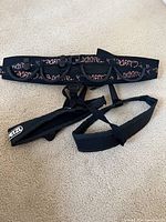 Full view of Petzl Bonnie climber's sit harness including padded waist belt with pink branding and adjustable leg loops.