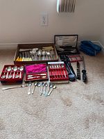 Full view of assortment of cutlery sets, boxed and loose.