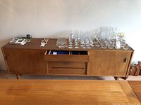 Straight-on front view of entire credenza with glassware on top