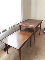 Two teak end tables side by side showing overall shape and size difference