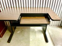 Top view showing bi-level dark wood grain laminate desktop and pull-out keyboard tray.