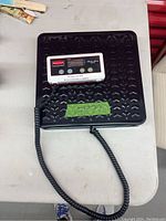 Top view of the black metal platform with connected digital display showing control buttons and Rubbermaid brand.