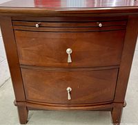 Front view of two drawer nightstand showing wood finish, drawer handles with tassel, and decorative groove detail.