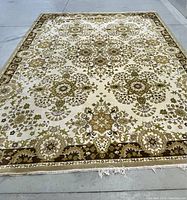 Top view of the wool carpet laid flat showing the floral and geometric pattern in olive and cream.