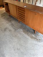 Full front and side view of credenza showing sliding doors, drawers and tapered legs