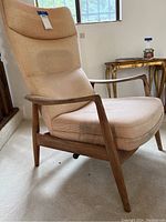 Front three-quarter view of chair showing maple frame, upholstery and overall design