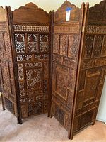 Front angle view showing all four carved panels and hinges
