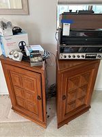 Two wood cabinets with stereo components on top, cables and headphone box