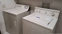 Side-by-side view of Kenmore washer and GE Profile dryer units in white.