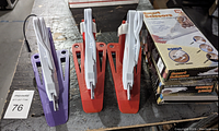 Three electric scissors in holders, two red and one purple, with original Smart Scissors box to the right.