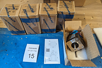 Five boxed stepper motors with one box open showing motor with metal shaft and foam protection.