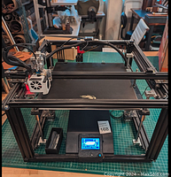 Front view of the Creality Ender 5 Plus 3D printer showing the frame, print bed with dragon logo, and control box with LCD screen below.