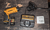 DeWalt cordless screwdriver, two 8V Max batteries, and charger shown on wooden surface.