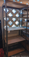 Full view of the shelving unit showing metal frame and 5 wood shelves in a well-lit room with diamond pattern glass windows.
