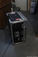 View of black road box standing upright showing metal corner protectors and handles.