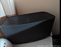 Black Sonos Play:5 speaker on table showing front grille and top controls