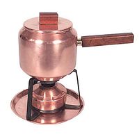 Copper fondue pot with wooden handle and lid knob shown on copper tray with black metal stand and fuel burner underneath.