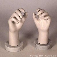 Pair of mannequin hands, front view, showing natural curved finger positions, mounted on cylindrical marble bases