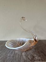 Full side view of swan glass dish showing shell-shaped bowl and tall curved swan neck with white tipped beak.
