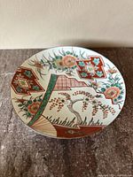 Top view of the antique Japanese porcelain plate showing colorful Imari style floral and geometric patterns