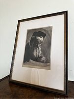 Angled full view of the framed etching showing the detailed portrait and the overall frame condition.